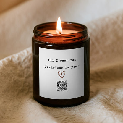 Égő Kiskedves „Dallamos” karácsonyi gyertya, a címkén rajzolt szív, QR-kód és az All I want for Christmas is you felirat